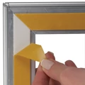 Kép 3/3 - Bel és kültéri plakátkeret üvegre, kétoldalas ragasztóval felrakható, imbuszkulcssal zárható, 32 mm profil, B0 méret
